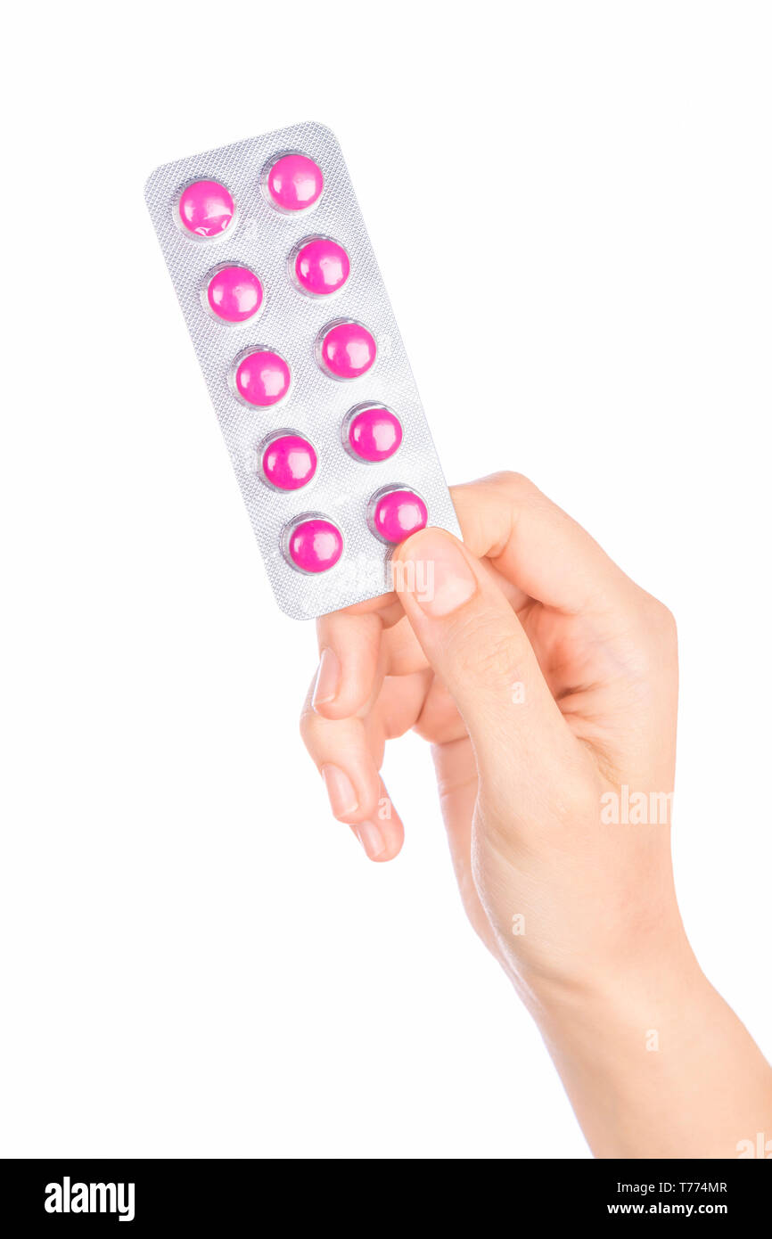 Donna mano azienda pillole compressa. Femmina di mano che tiene la prescrizione pillola su sfondo bianco. Foto Stock