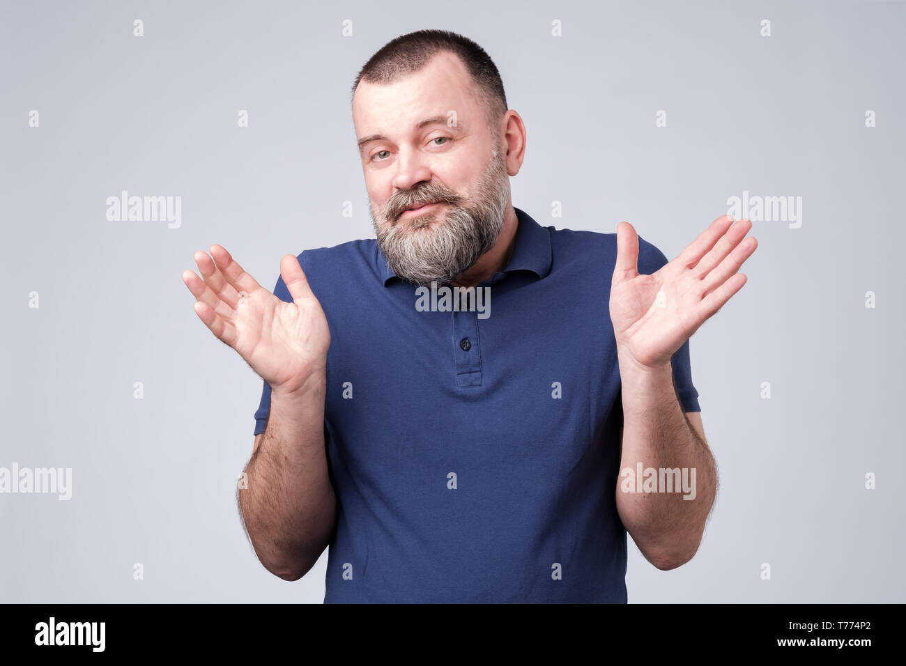 Uomo Barbuto in blu t-shirt scrollare le spalle Foto Stock