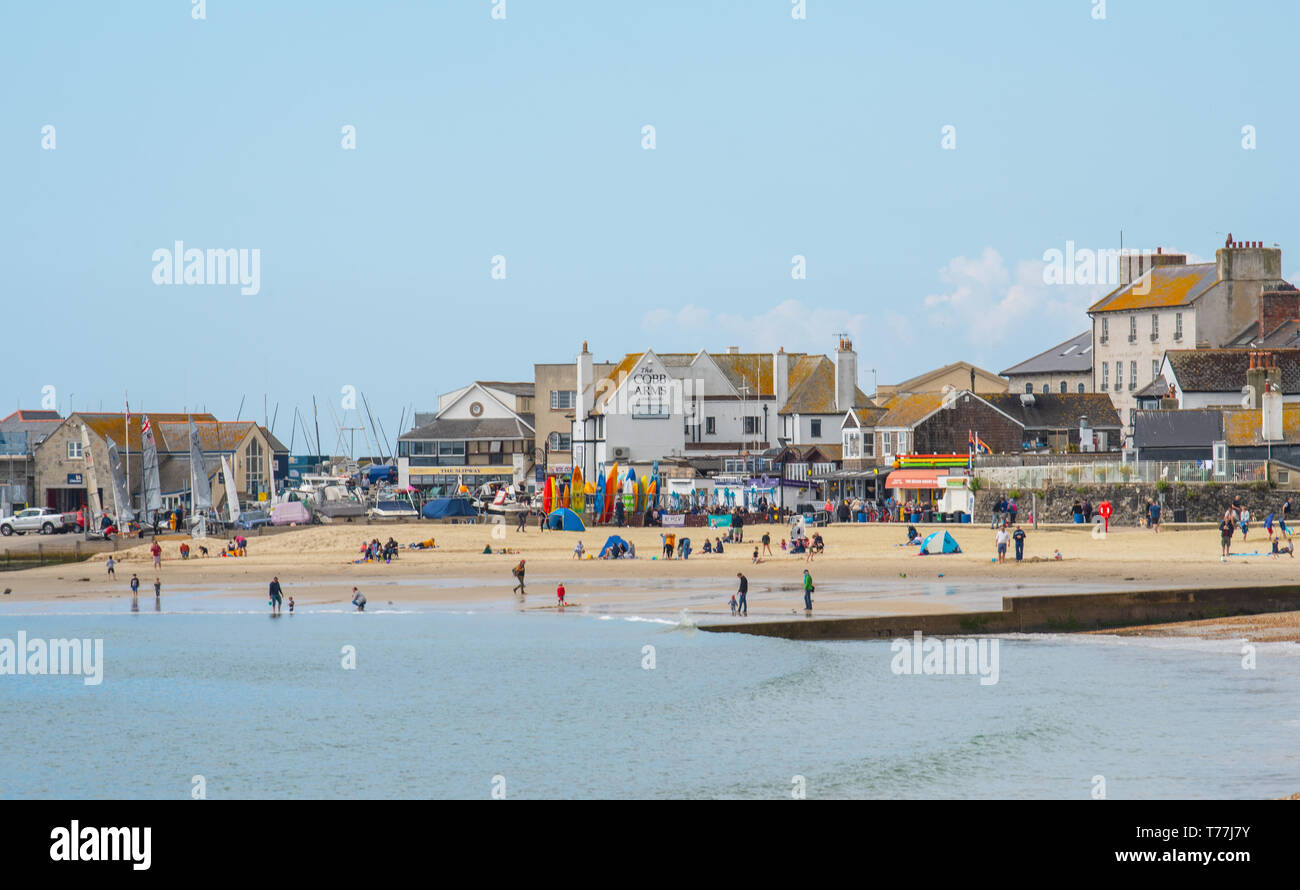 Lyme Regis, Dorset, Regno Unito. Il 5 maggio 2019. Regno Unito: Meteo visitatori godere di caldo e soleggiato incantesimi con una leggera brezza sulla spiaggia a Lyme Regis. Le condizioni dello scambiatore di calore sono previsti per il week-end festivo di maggio. Credito: Celia McMahon/Alamy Live News. Foto Stock