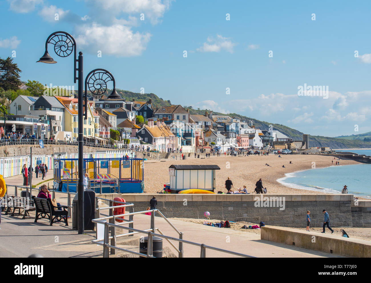 Lyme Regis, Dorset, Regno Unito. Il 5 maggio 2019. Regno Unito: Meteo visitatori godere di caldo e soleggiato incantesimi con una leggera brezza sulla spiaggia a Lyme Regis. Le condizioni dello scambiatore di calore sono previsti per il week-end festivo di maggio. Credito: Celia McMahon/Alamy Live News. Foto Stock