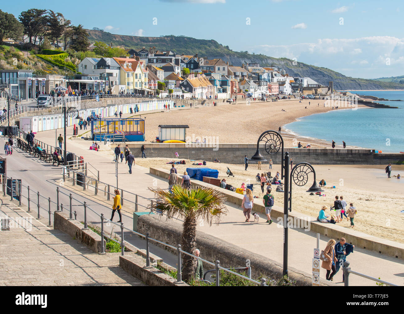 Lyme Regis, Dorset, Regno Unito. Il 5 maggio 2019. Regno Unito: Meteo visitatori godere di caldo e soleggiato incantesimi con una leggera brezza sulla spiaggia a Lyme Regis. Le condizioni dello scambiatore di calore sono previsti per il week-end festivo di maggio. Credito: Celia McMahon/Alamy Live News. Foto Stock