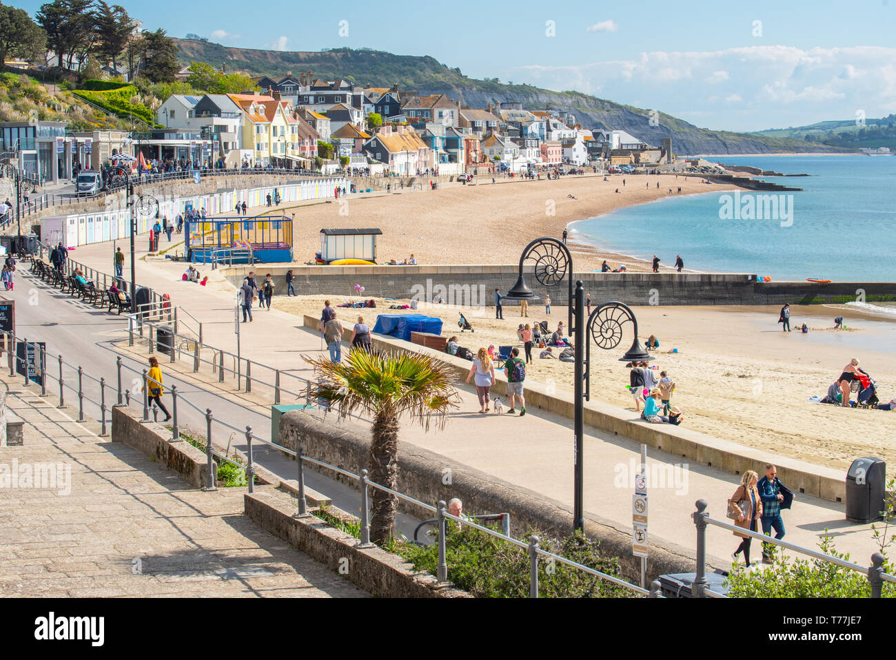 Lyme Regis, Dorset, Regno Unito. Il 5 maggio 2019. Regno Unito: Meteo visitatori godere di caldo e soleggiato incantesimi con una leggera brezza sulla spiaggia a Lyme Regis. Le condizioni dello scambiatore di calore sono previsti per il week-end festivo di maggio. Credito: Celia McMahon/Alamy Live News. Foto Stock