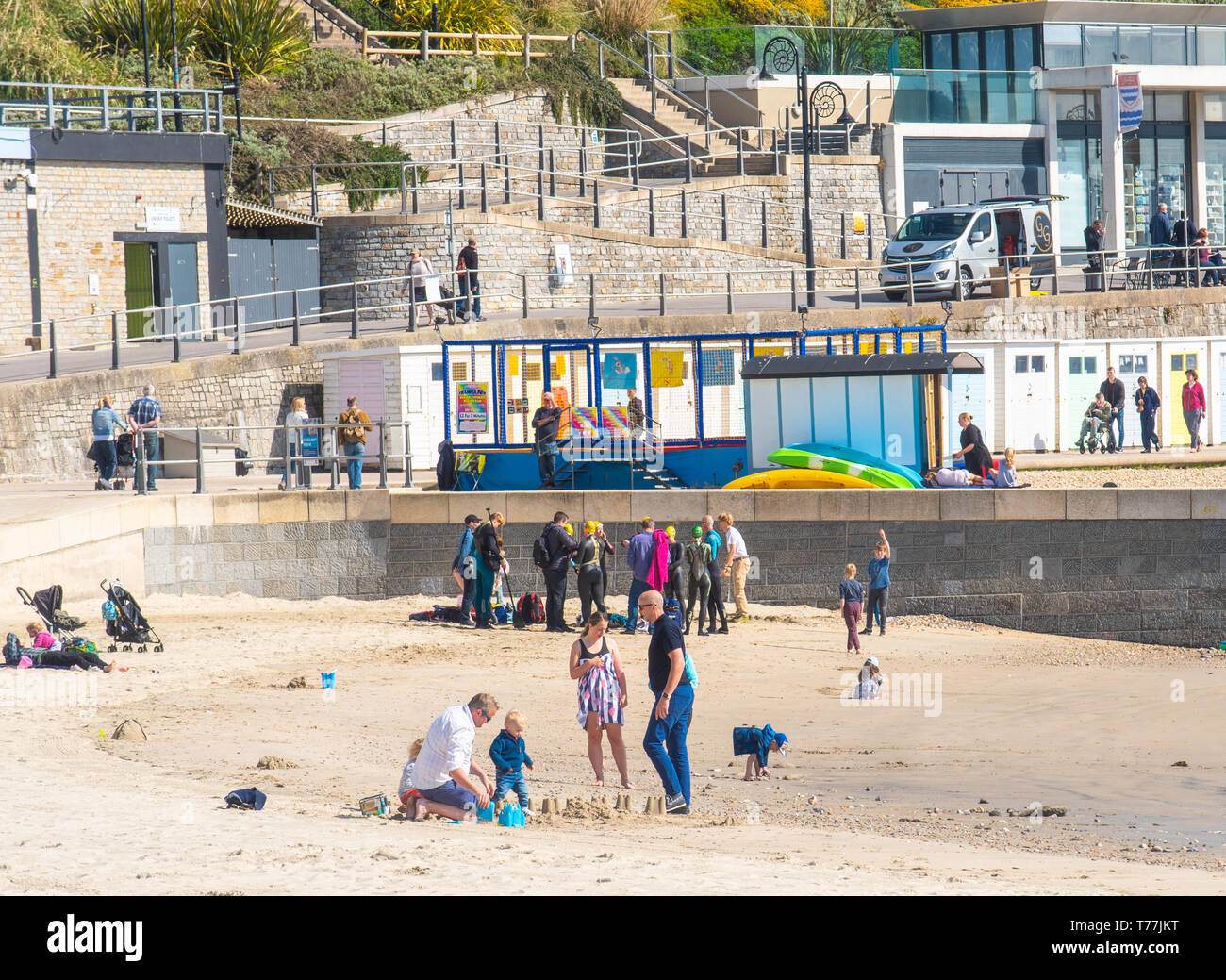 Lyme Regis, Dorset, Regno Unito. Il 5 maggio 2019. Regno Unito: Meteo visitatori godere di caldo e soleggiato incantesimi con una leggera brezza sulla spiaggia a Lyme Regis. Le condizioni dello scambiatore di calore sono previsti per il week-end festivo di maggio. Credito: Celia McMahon/Alamy Live News. Foto Stock