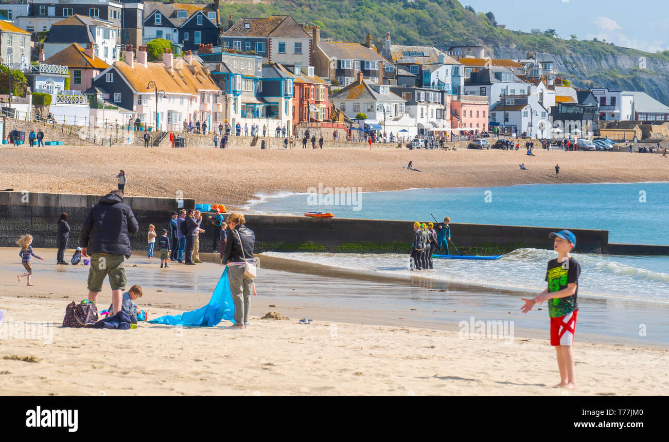 Lyme Regis, Dorset, Regno Unito. Il 5 maggio 2019. Regno Unito: Meteo visitatori godere di caldo e soleggiato incantesimi con una leggera brezza sulla spiaggia a Lyme Regis. Le condizioni dello scambiatore di calore sono previsti per il week-end festivo di maggio. Credito: Celia McMahon/Alamy Live News. Foto Stock