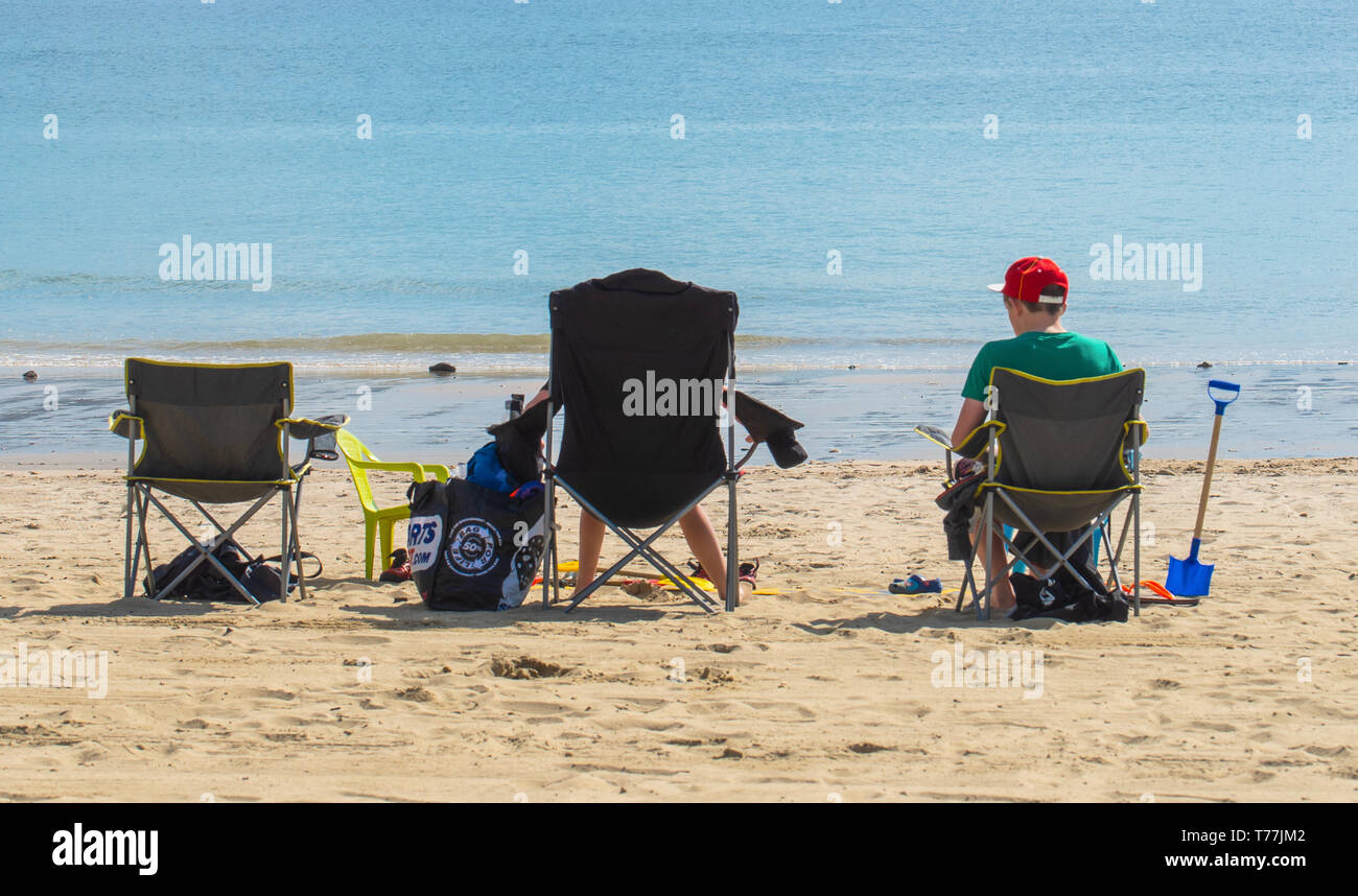 Lyme Regis, Dorset, Regno Unito. Il 5 maggio 2019. Regno Unito: Meteo visitatori godere di caldo e soleggiato incantesimi con una leggera brezza sulla spiaggia a Lyme Regis. Le condizioni dello scambiatore di calore sono previsti per il week-end festivo di maggio. Credito: Celia McMahon/Alamy Live News. Foto Stock