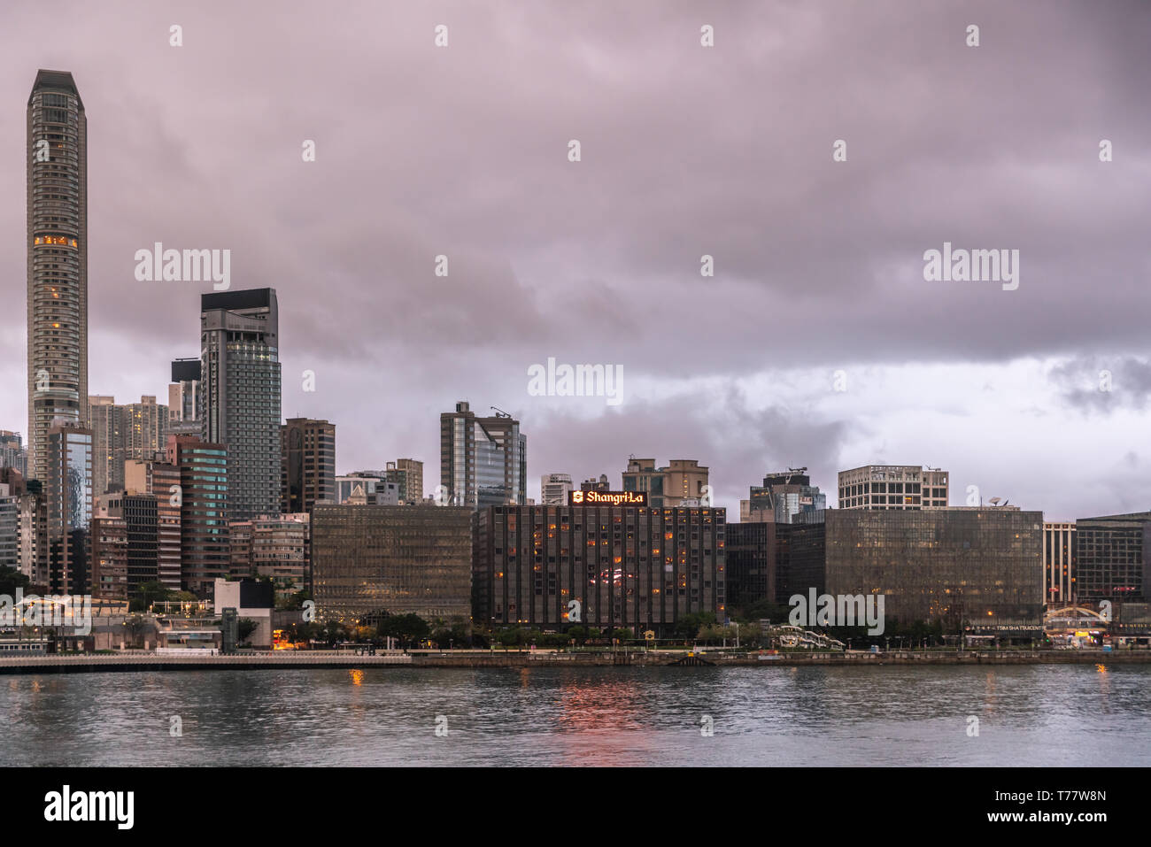 Hong Kong, Cina - 7 Marzo 2019: la mattina molto presto in dark sky piovosa. Lo skyline di Kowloon centrata a Shangri-la hotel e Tsim Sha Tsui Promenade wi Foto Stock