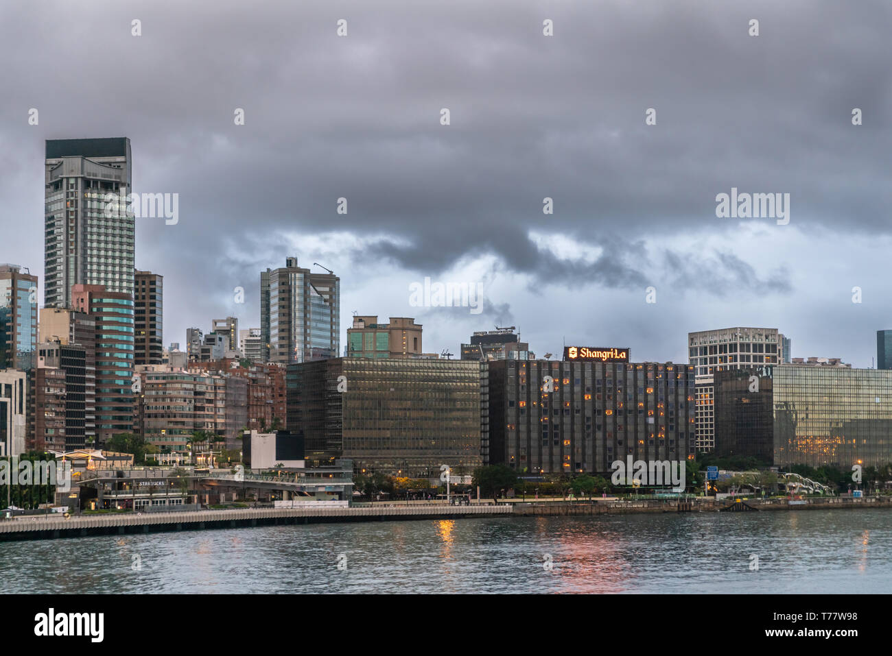 Hong Kong, Cina - 7 Marzo 2019: la mattina molto presto in dark sky piovosa. Lo skyline di Kowloon centrata a Shangri-la hotel e Tsim Sha Tsui Promenade wi Foto Stock