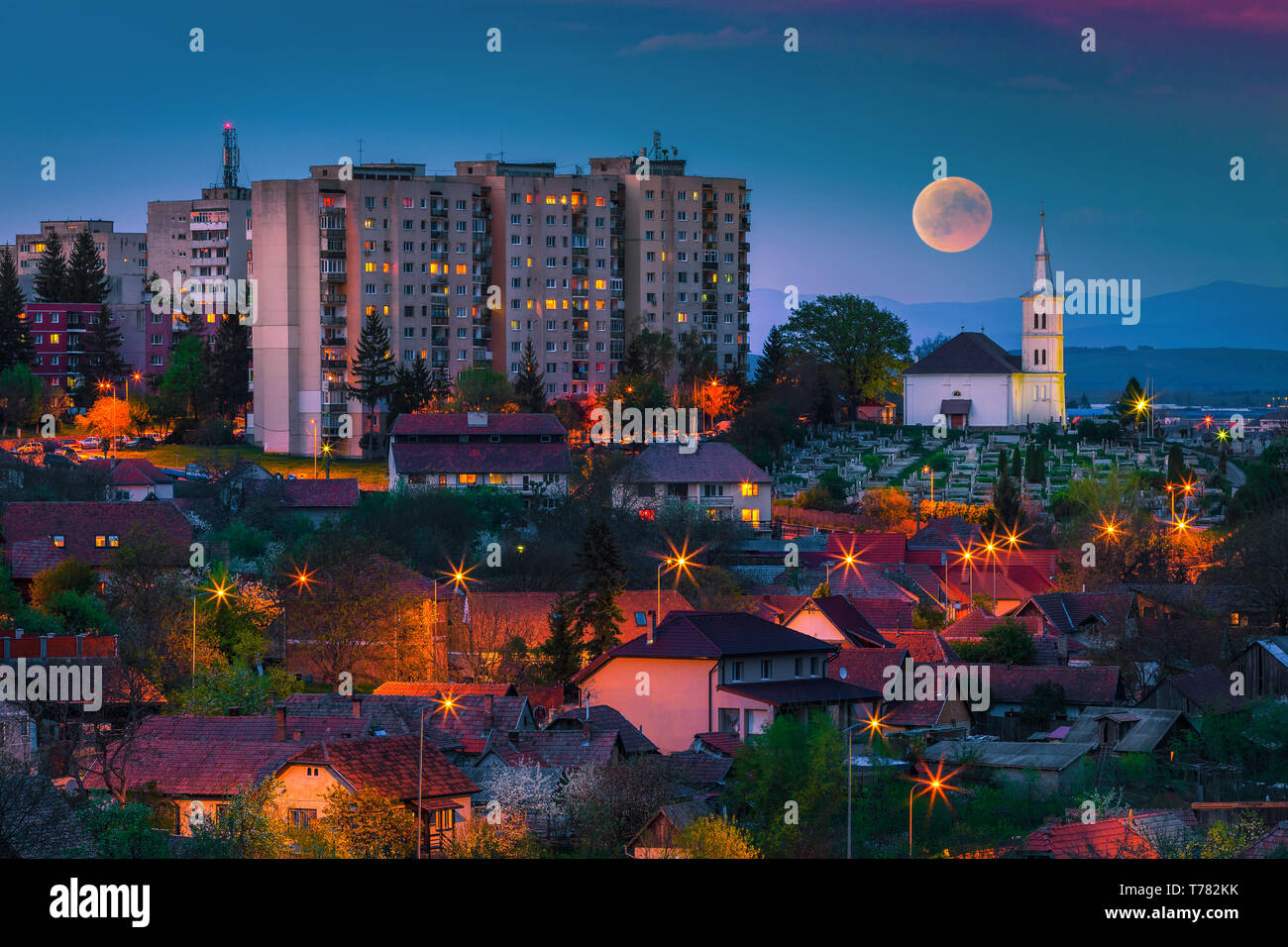 Pittoresca scena serale. Panorama della città di notte con la luna piena, Sfantu Gheorghe, Transilvania, Romania, Europa Foto Stock