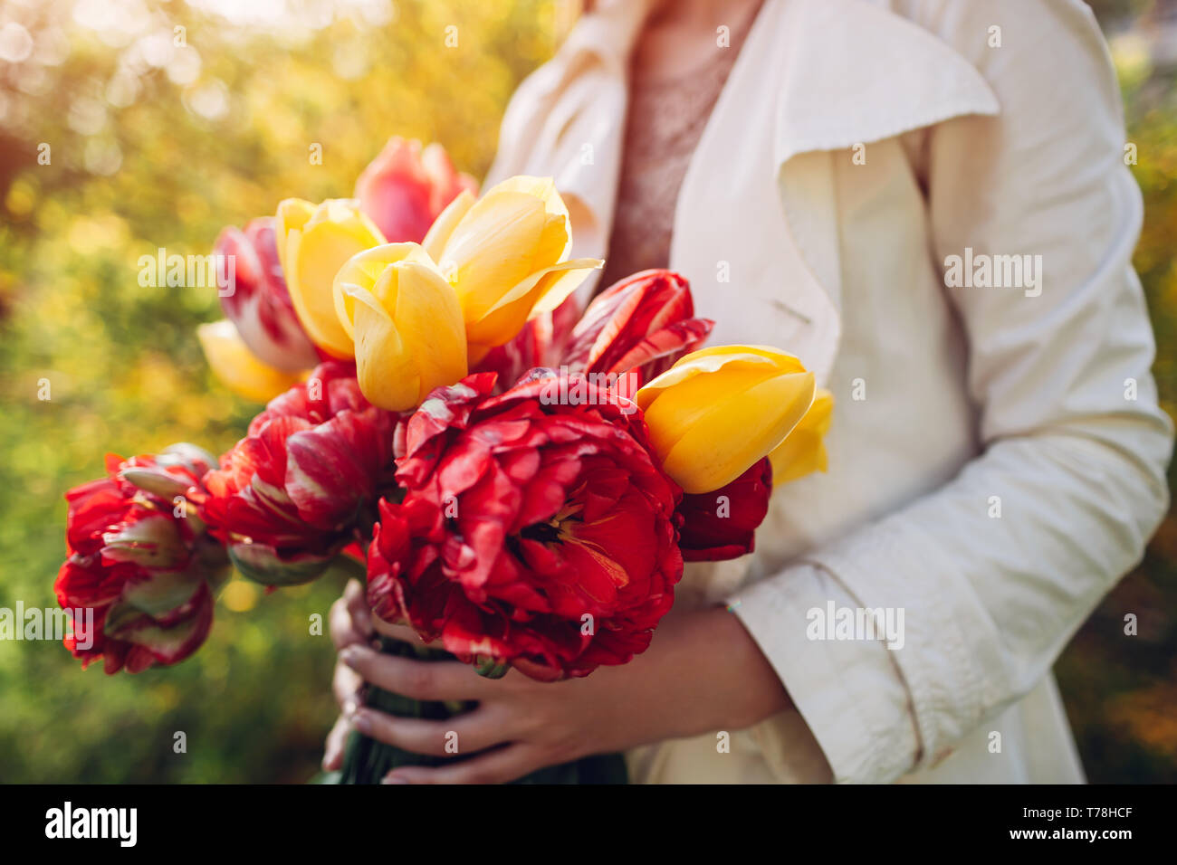 La donna tiene un bouquet di tulipani colorati all'esterno. Presente per la festa della mamma Foto Stock