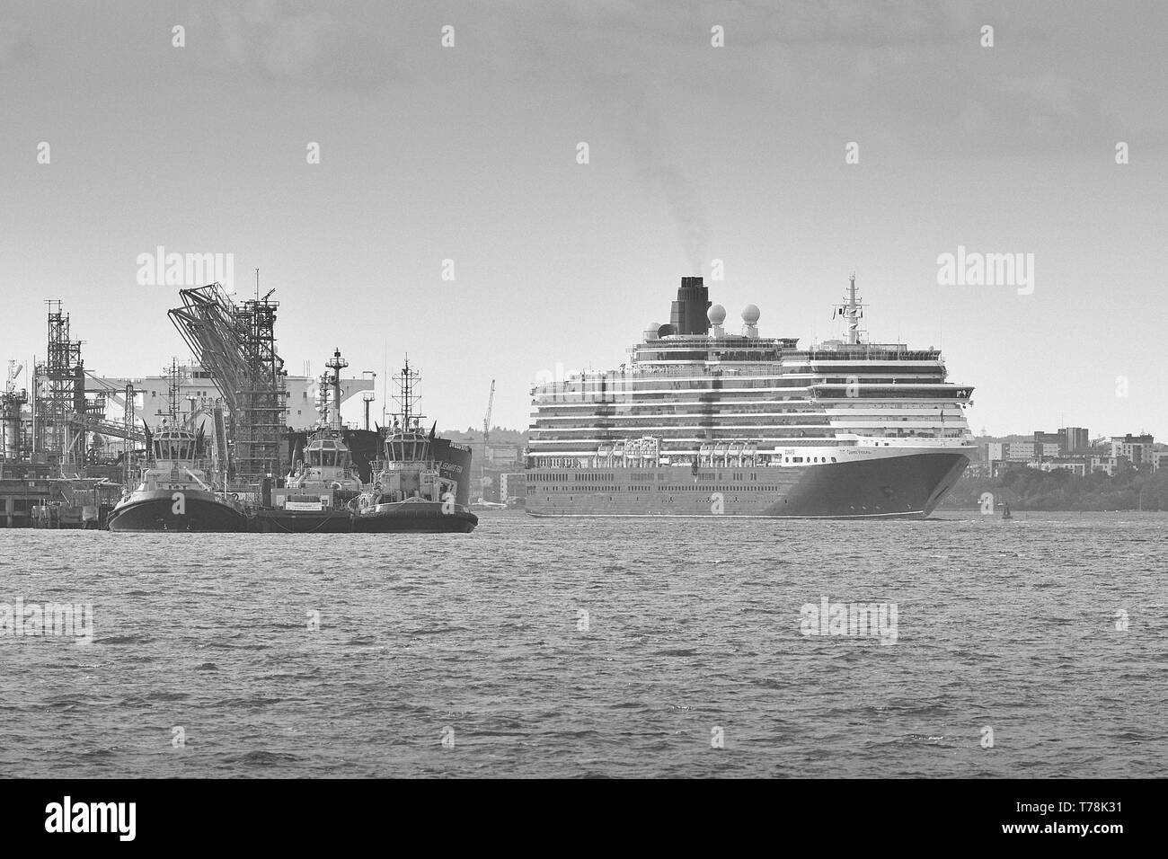 Foto in bianco e nero della Cunard Line, Cruise Liner, MS Queen Victoria, in corso oltre la raffineria petrolifera Fawley mentre parte da Southampton, in direzione Foto Stock