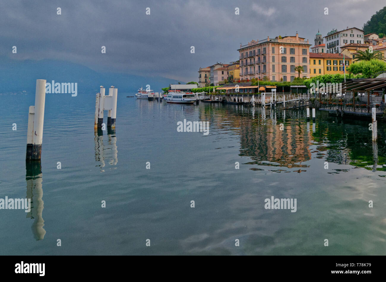 Una vista attraverso il porto all'Hotel Metropole e altri edifici colorati di Bellagio, con riflessi nell'acqua del lago di Como Foto Stock