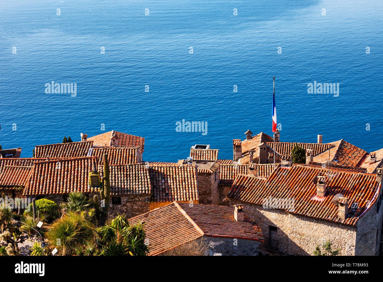 Eze Village in Francia, vista sopra i tetti delle case tradizionali e big blu del mare della Riviera Francese. Foto Stock