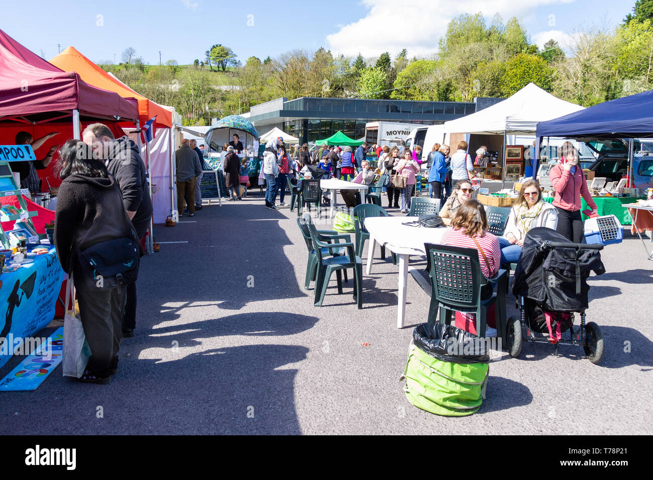 Gli amanti dello shopping in un mercato di un paese in una luminosa giornata di sole. Foto Stock