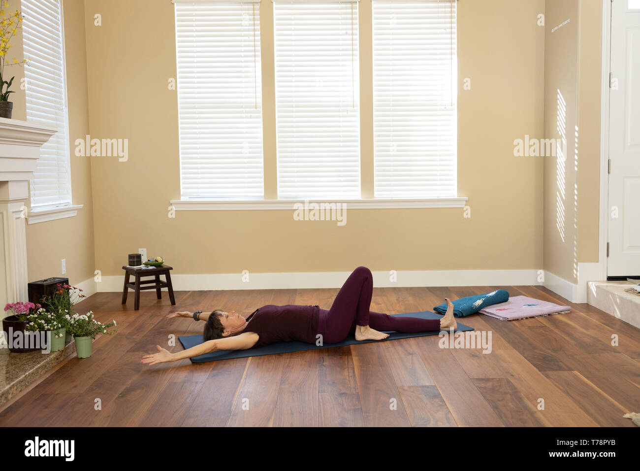 Lo Yoga pone sui bracci posteriore tettuccio di un ginocchio piegato Foto Stock