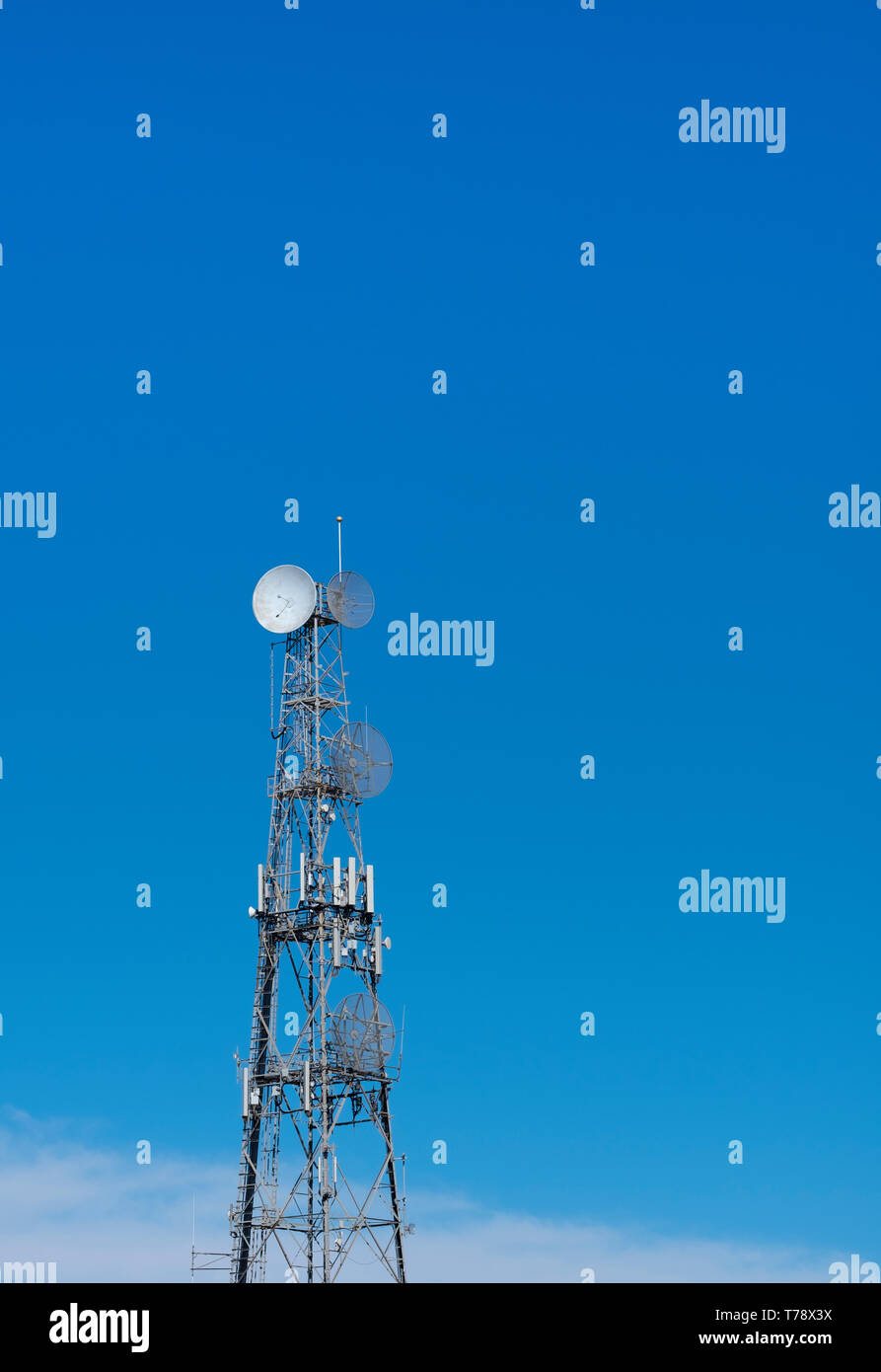 Torre di comunicazione contro un cielo blu chiaro Foto Stock