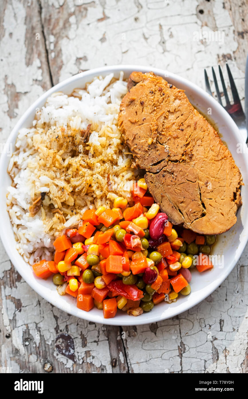 Arrosto di maiale con riso e insalata di verdure Foto Stock