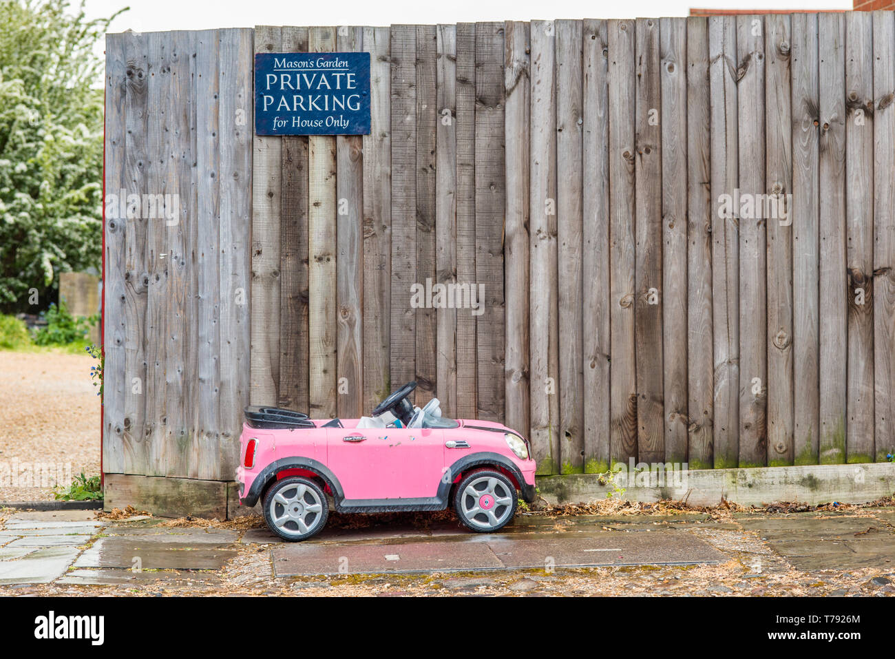 Immagine divertente di un piccolo bambino giocattolo auto parcheggiate al di sotto di parcheggio privato segno. Visto, Cambridge, Inghilterra. Foto Stock