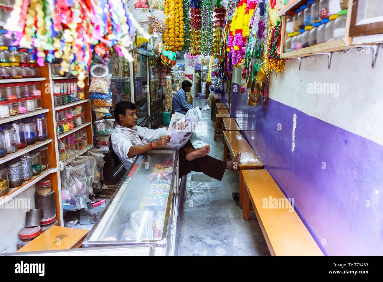 Dacca in Bangladesh : un uomo reas la carta presso un negozio di devozionale e articoli religiosi in Shankhari Bazaar aka strada indù di una delle zone più antiche o Foto Stock