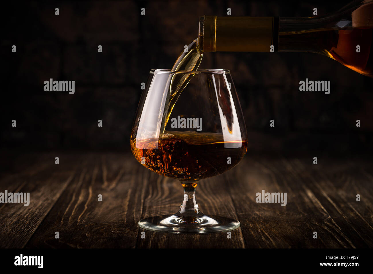 Versando il brandy o il cognac in vetro. Foto Stock