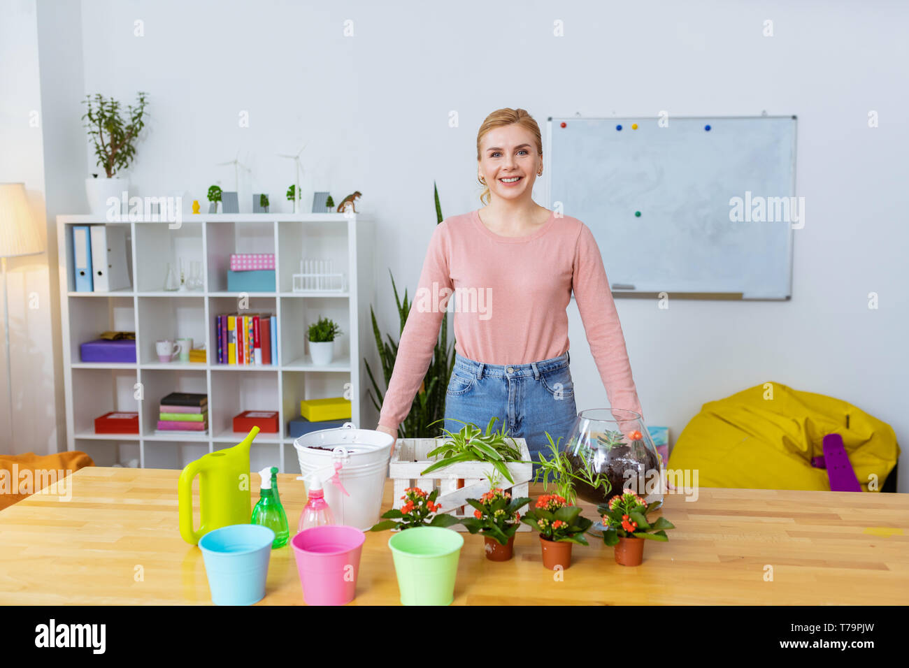 Biondo e insegnante. Emozionato biondo e insegnante di scuola primaria sorridente largamente mentre pronto per la lezione di botanica Foto Stock