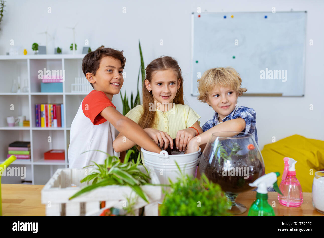 Entusiasti scolari. Trasmissione via IR ed entusiasti di scolari potting cactus e piante insieme a lezione di ecologia Foto Stock