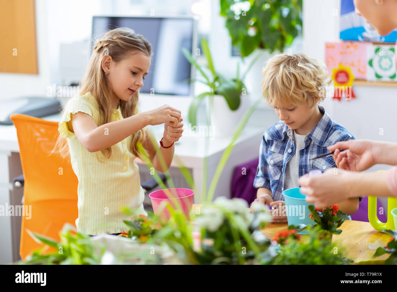 Un ragazzo e una ragazza. Un ragazzo e una ragazza sensazione eccitato durante l'apertura di gouache prima che i vasi da fiori di colorazione Foto Stock