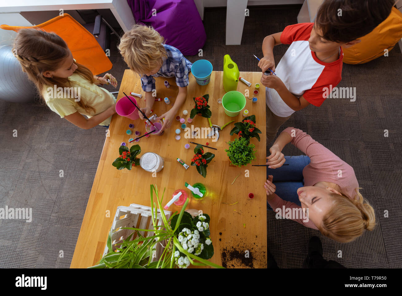 Tempo di colorazione. Gli alunni e gli insegnanti sensazione gioiosa mentre le benne di colorazione per impianti a lezione di ecologia Foto Stock
