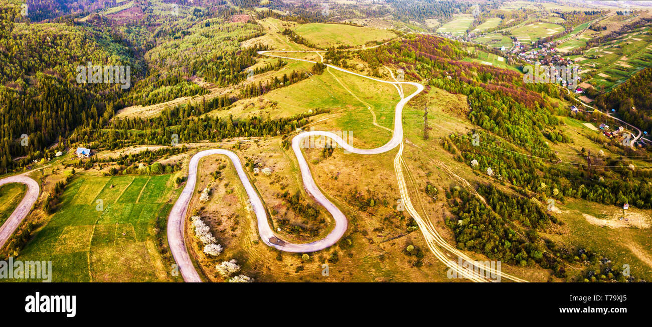 Piegatura curva strada a serpentina sulle colline. Avvolgimento strada alpina in montagna. Carpazi, Ucraina Foto Stock