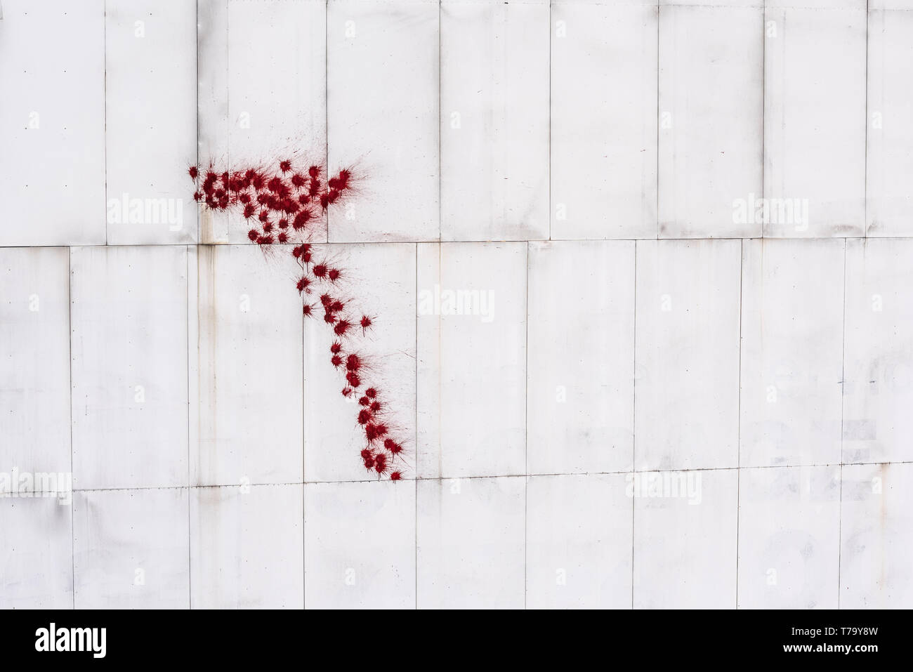 New York, Rosso gli spruzzi di vernice sul muro bianco forma della pistola Foto Stock