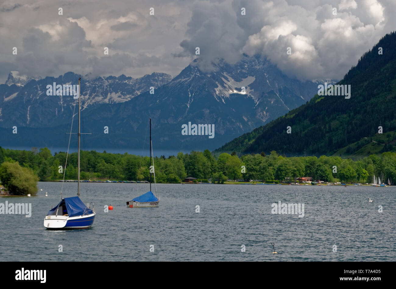 Ancorate barche a vela su Zeller (lago Zell) rivolti verso le montagne di fronte Zell am See in Austria Foto Stock