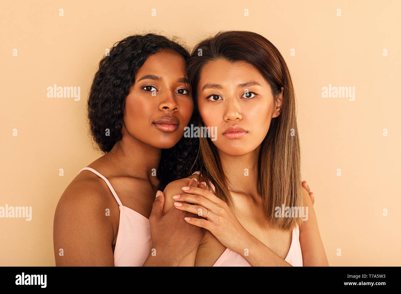 Due diverse donne amici contro uno sfondo colorato Foto Stock