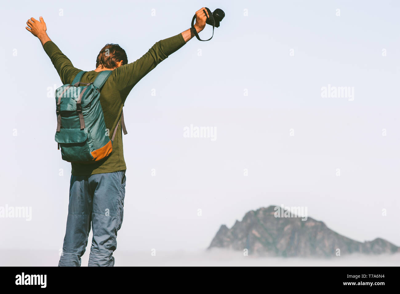 Uomo felice Fotografo in viaggio in montagna successo bracci sollevati avventura lifestyle leisure weekend trekking outdoor con zaino Foto Stock