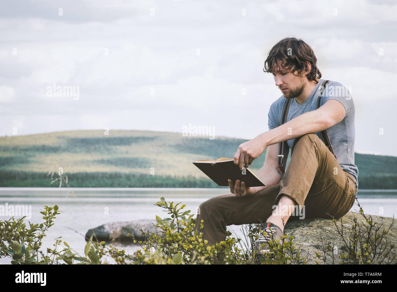 Studente uomo libro lettura outdoor auto educazione vacanze estive lifestyle Foto Stock