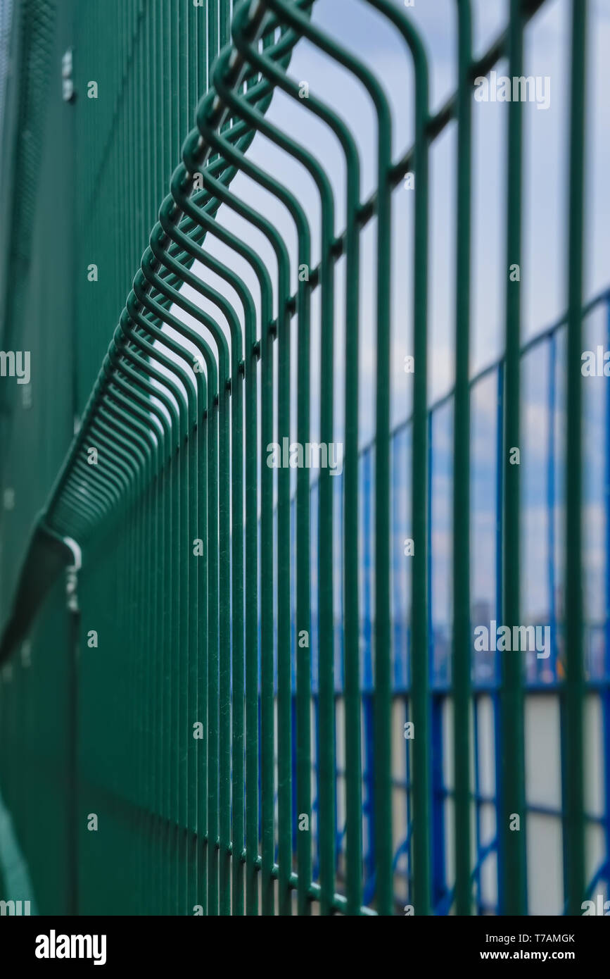 Recinzione metallica attorno alla corte di hockey. Recinzione in metallo di colore verde per proteggere la corte di hockey su sfondo di texture. Foto Stock