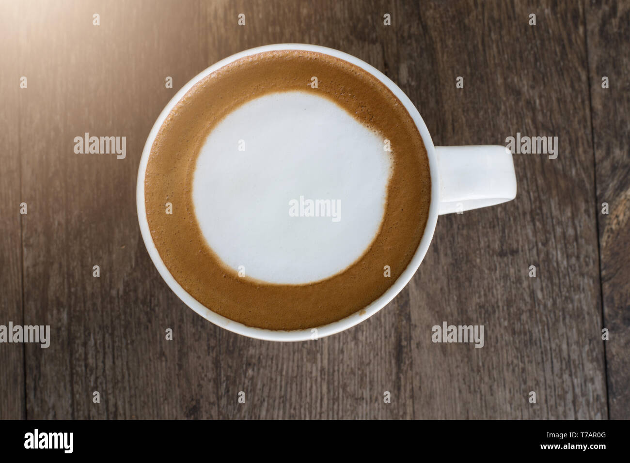 Caffè caldo con la schiuma di latte su sfondo di legno. Foto Stock