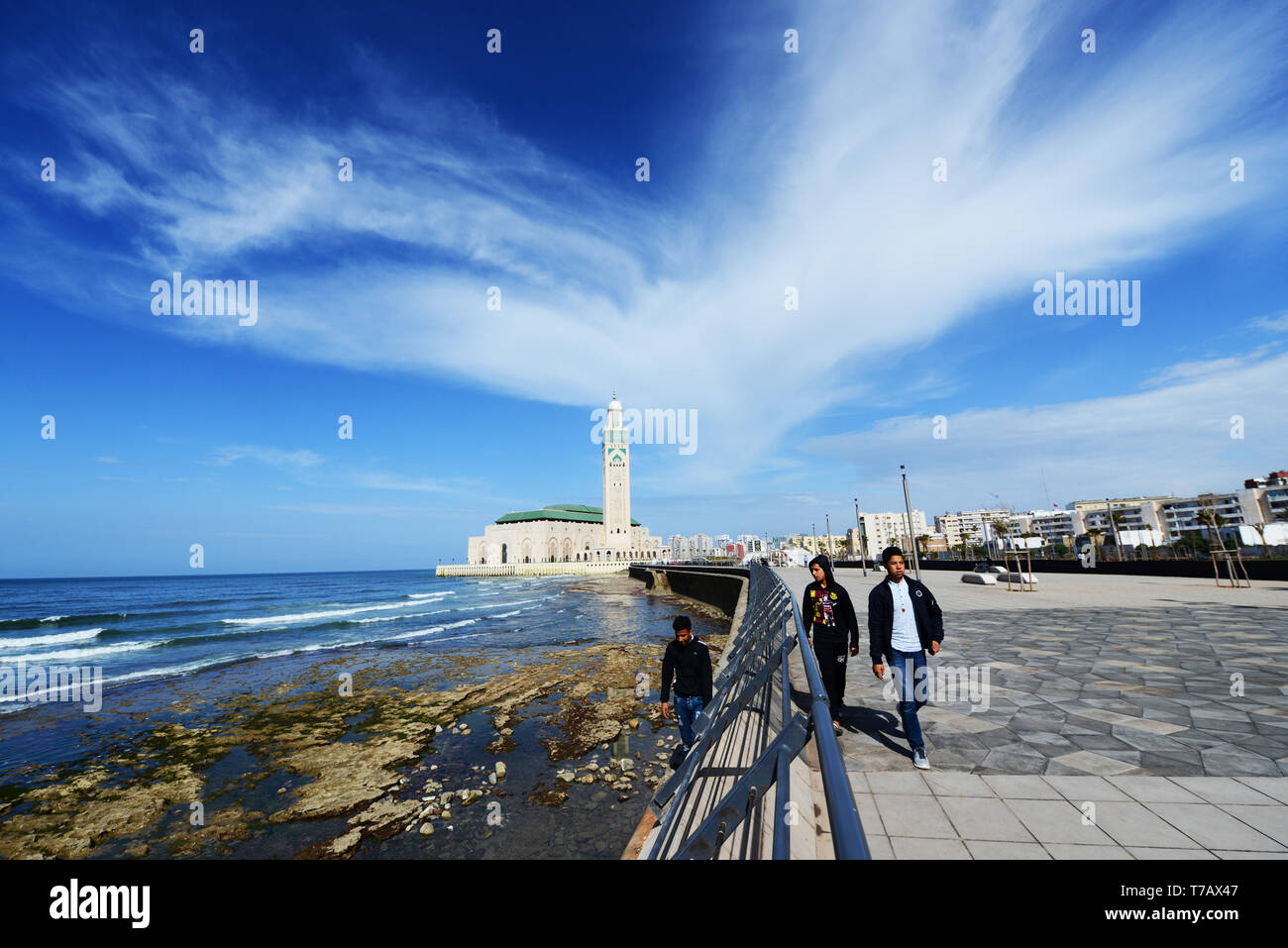 La nuova e bella passeggiata lungo la costa dell'oceano Atlantico con la moschea di Hassan II in background. Foto Stock