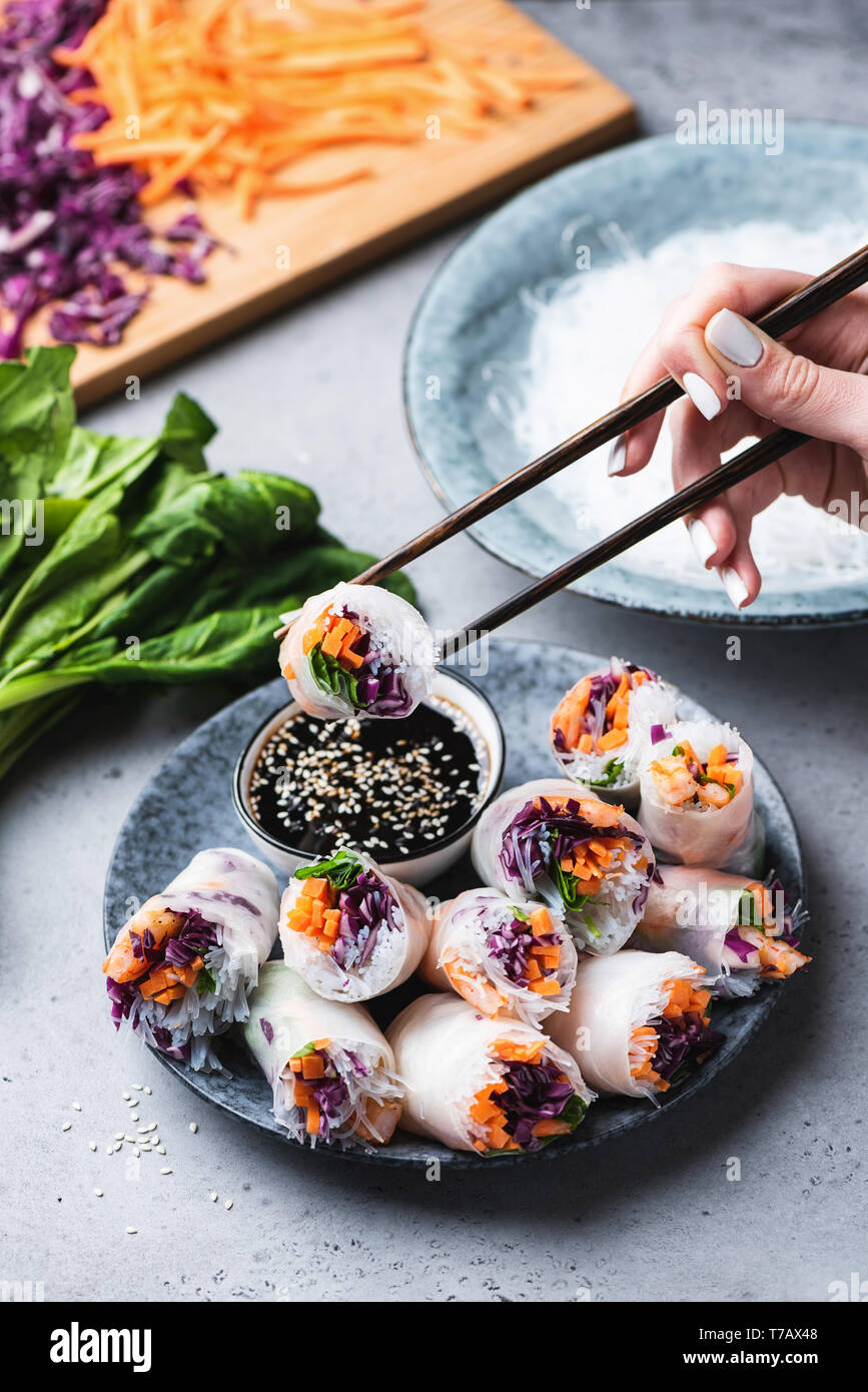 La carta di riso rotoli o bobine a molla con base teriyaki salsa di immersione, cucina asiatica. Mangiare involtini primavera Foto Stock