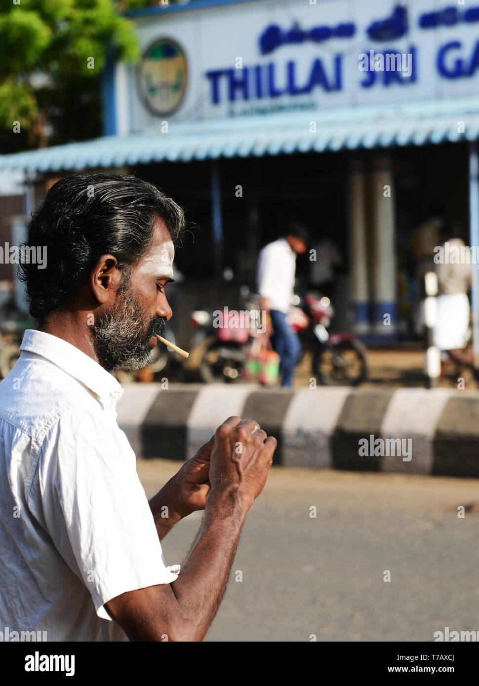 Un uomo Tamil fumare una Beedi - un tradizionale South Asian sigaretta. Foto Stock