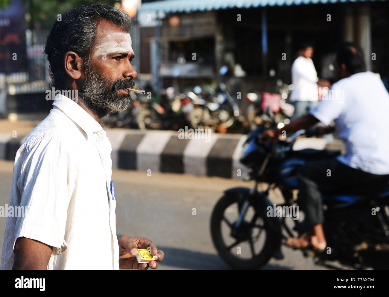 Un uomo Tamil fumare una Beedi - un tradizionale South Asian sigaretta. Foto Stock