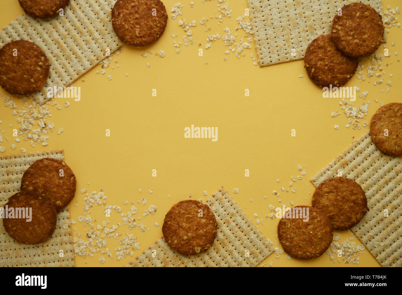 Sfondo giallo con matzo, fiocchi di avena e i cookie con i cereali. Deliziosa la farina di frumento prodotti. Foto Stock