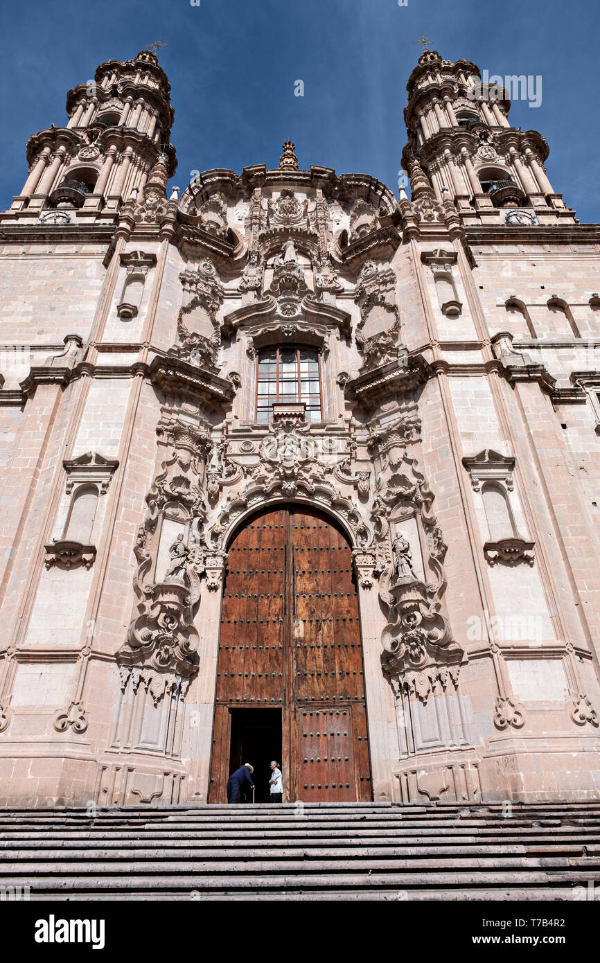 La raffinata facciata barocca della parrocchia di Nostra Signora dell'Assunzione chiesa localmente noto come Parroquia de la Asunción de Maria in Lagos de Moreno, Stato di Jalisco, Messico. Lo stile barocco chiesa parrocchiale è il più grande della città ed è stato costruito nel 1741 per la maggior parte di una pietra rosa locale noto come cantera rosa che dà alla Chiesa un colore rosa tinta. Foto Stock