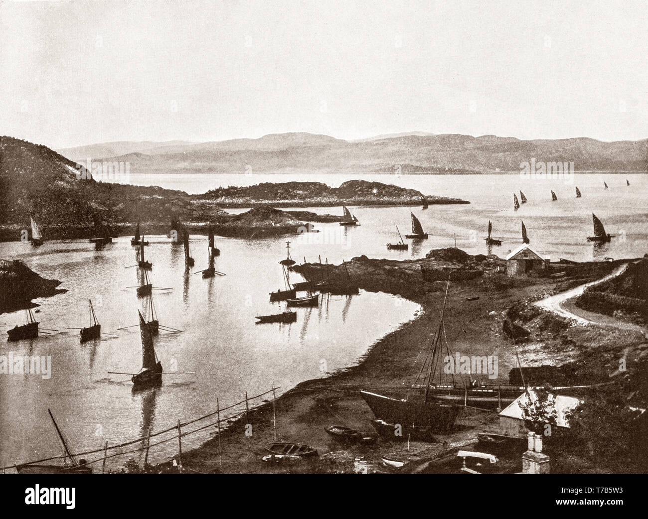 Un palazzo di fine ottocento vista delle barche da pesca che lascia il porto di Tarbert, un villaggio nelle acque ad ovest della Scozia, nell'Argyll and Bute area del consiglio. È costruito attorno a Oriente Loch Tarbert, un ingresso di Loch Fyne, e si estende oltre l'istmo che collega la penisola di Kintyre a Knapdale e West Loch Tarbert. Tarbert socio-prosperità economica è venuto come la porta si è sviluppata in un paese di pescatori. A sua altezza il Loch Fyne aringhe attratto centinaia di navi a Tarbert. Foto Stock