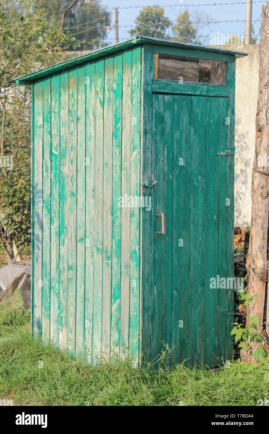 Un dipinto di verde all'aperto toilette in legno in campagna Foto Stock