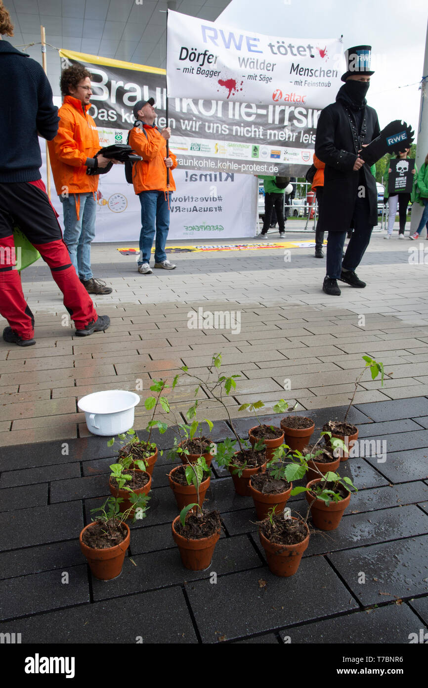 Mangiare, Deutschland. 03 Maggio, 2019. Poster con la scritta 'RWE uccide Doerfer Waelder Menschen", Attac, in primo piano degli alberi giovani in vasi da fiori, dimostrazione di attivisti del clima di fronte al Grugahalle, protesta contro la lignite e carbone, elettricità, energia nucleare, il cambiamento climatico, la Riunione Generale Annuale di RWE AG su 03.05.2019 in Grugahalle in cibo | Utilizzo di credito in tutto il mondo: dpa/Alamy Live News Foto Stock