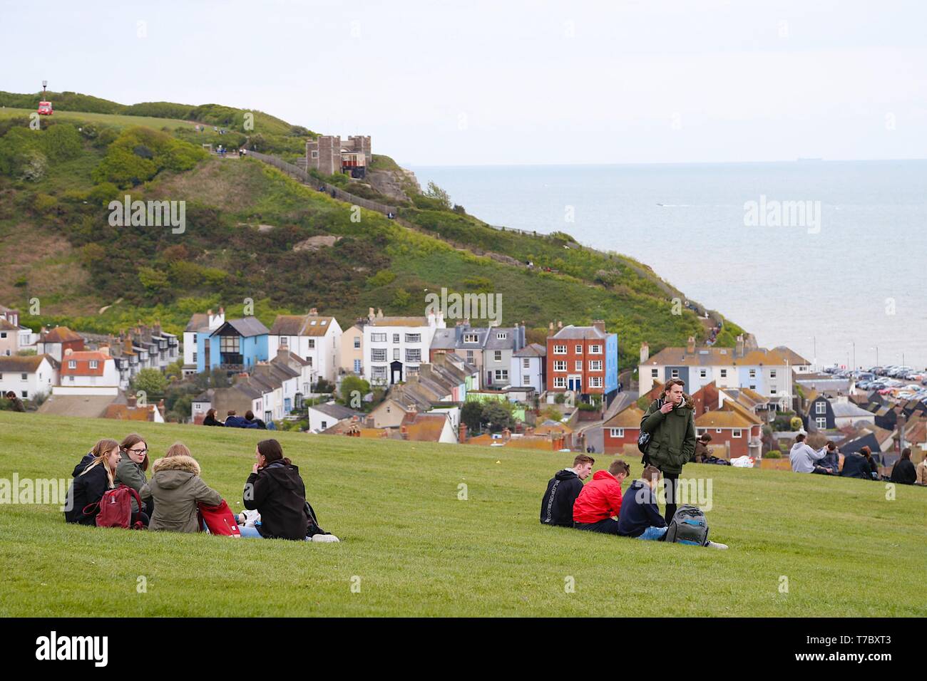 Hastings, East Sussex, Regno Unito. 06 Maggio, 2019. Regno Unito Meteo: un brillante ma pomeriggio freddo come il tempo prende una svolta per il peggio in Hastings, East Sussex. Persone sedersi in erba sulla sommità della collina di West Cliff godendo la Mayday bank holiday. © Paul Lawrenson 2019, Photo credit: Paolo Lawrenson/Alamy Live News Foto Stock