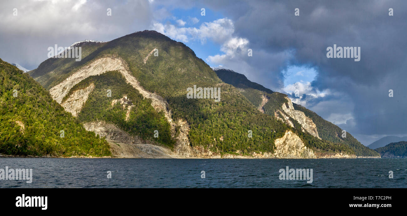 Moutainous unihabited in gran parte boschiva costiera di Patagonia visto da una nave da crociera a San Rafael ghiacciaio nel sud del Cile. Foto Stock