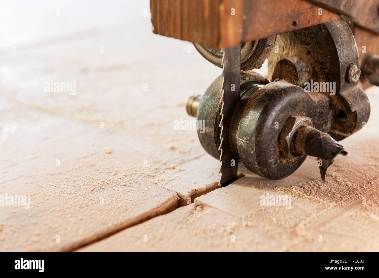 Primo piano della guida meccanica della lama di un vecchio di una sega a nastro con fine polvere di legno. Foto Stock