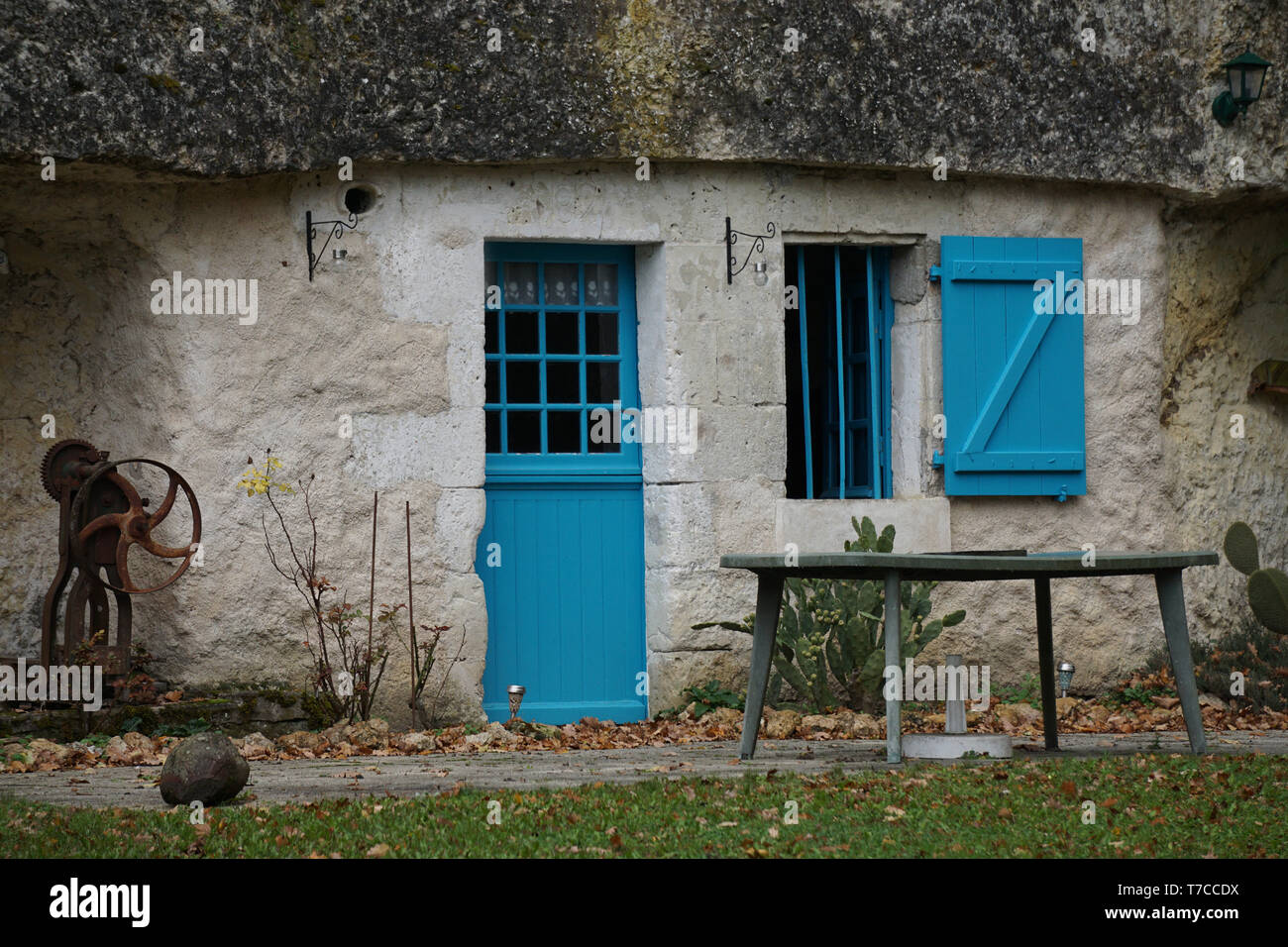 Finestra di turchese, otturatore e la porta di una casa troglodita con un giardino Foto Stock