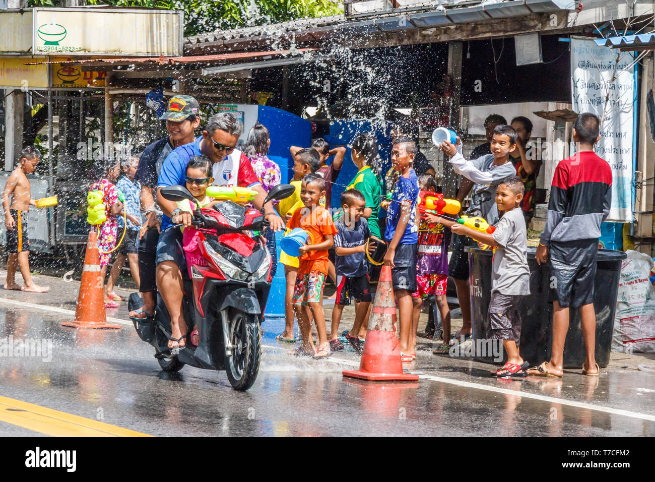 Phuket, Tailandia - 13 Aprile 2017: persone su una moto completamente fradicia da Songkran partecipanti. Questo è il modo in cui i thailandesi celebrano il loro nuovo anno. Foto Stock
