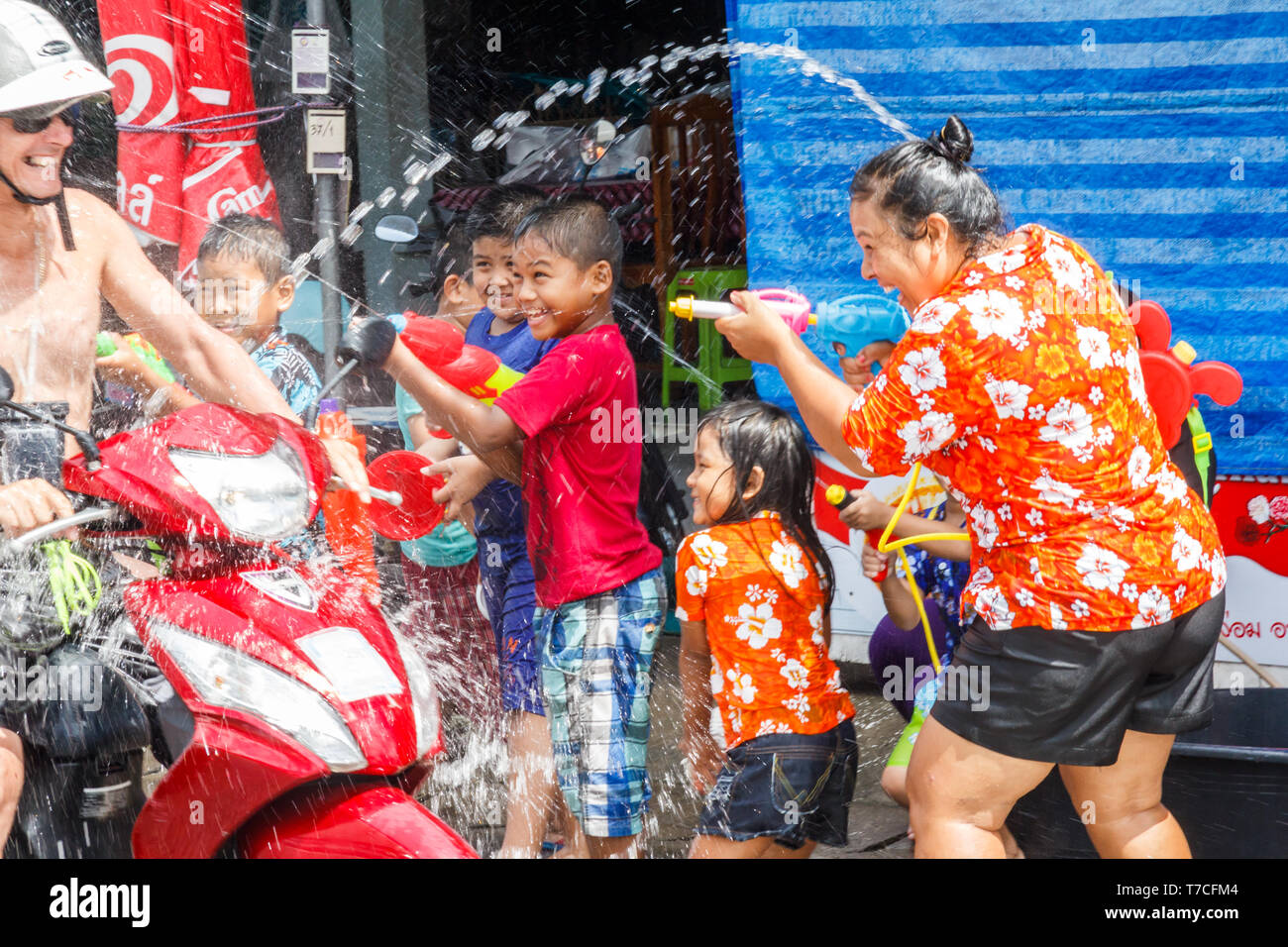 Phuket, Tailandia - 13 Aprile 2017: persone su una moto completamente fradicia da Songkran partecipanti. Questo è il modo in cui i thailandesi celebrano il loro nuovo anno. Foto Stock